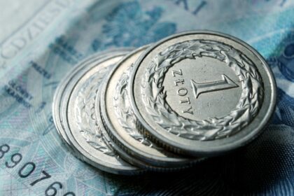 Close-up of Polish zloty coins stacked on a banknote. Financial concept.