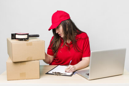 Młoda dorosła ładna kobieta pracownik firmy z pudełkami