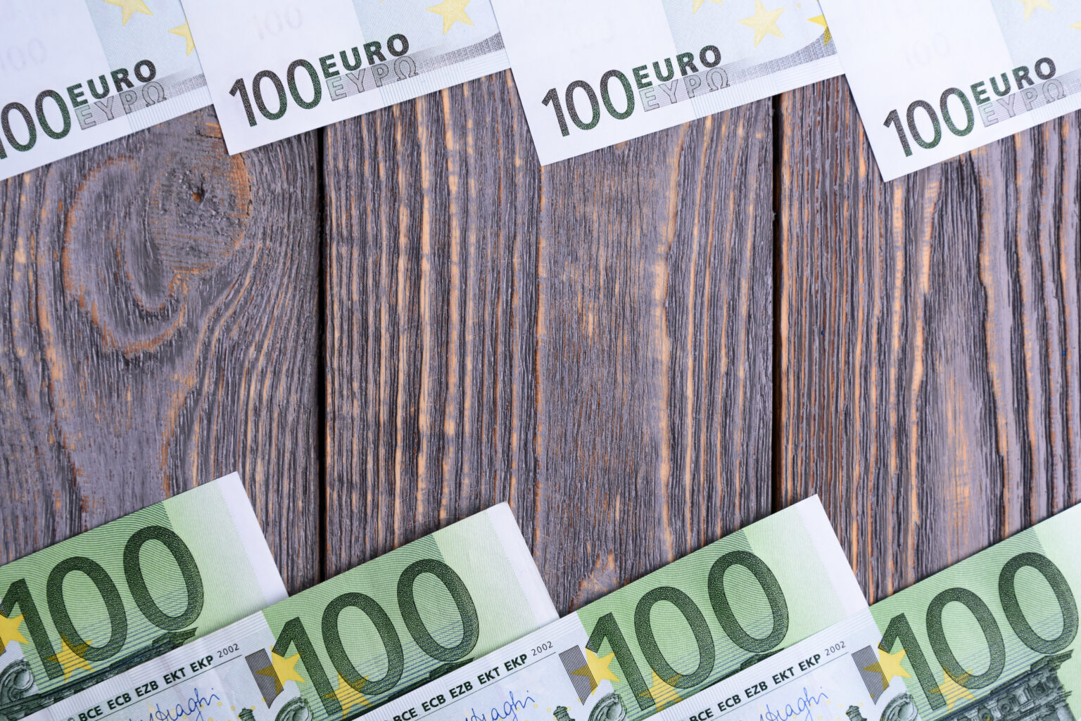 Euro banknoty kłamają ramę przy drewnianym tłem.