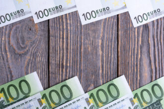 Euro banknoty kłamają ramę przy drewnianym tłem.