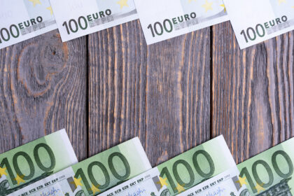 Euro banknoty kłamają ramę przy drewnianym tłem.