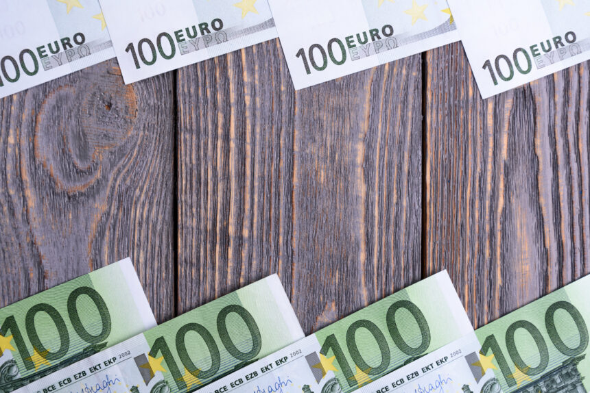Euro banknoty kłamają ramę przy drewnianym tłem.
