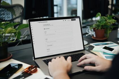 A person typing on a laptop on a desk