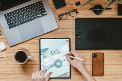 person holding black ipad near macbook pro