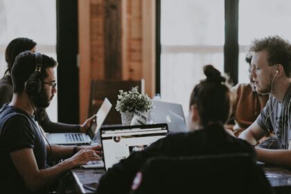 selective focus photography of people sits in front of table inside room